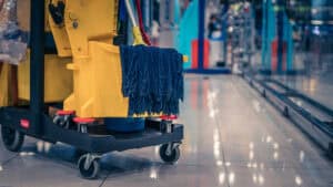 cleaning cart with mop and cleaning tools at a commercial space.